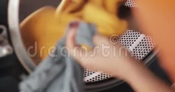 女人手把衣服装进洗衣机自助公共洗衣店视频的预览图