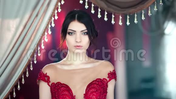中等身材可爱的西班牙年轻性感女人晚上穿着闪闪发光的红色连衣裙视频的预览图