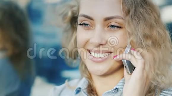 有魅力的女人在电话里说话的肖像风在她的头发里吹积极的情绪视频的预览图