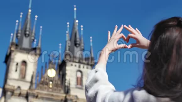 欣赏着令人惊叹的历史城堡的女性旅行者用双手回视来表达爱意视频的预览图