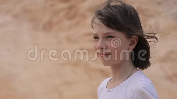 一个十几岁的女孩在山溪边的岩石上的肖像与自然团结健康的生活方式视频的预览图