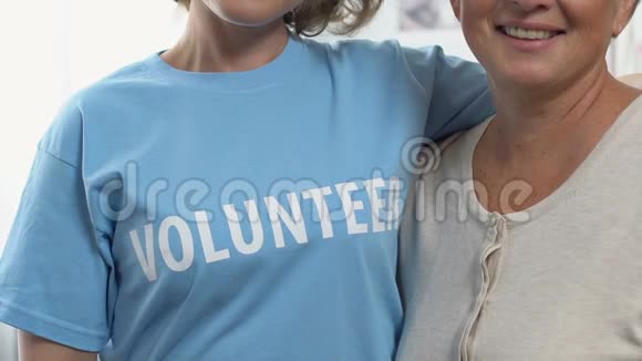 两个女人指着T恤上的志愿者词提供工作来帮助人们视频的预览图