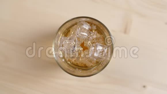 在浅棕色的木桌上放满了带冰块的奶油苏打水饮料的顶景玻璃视频的预览图