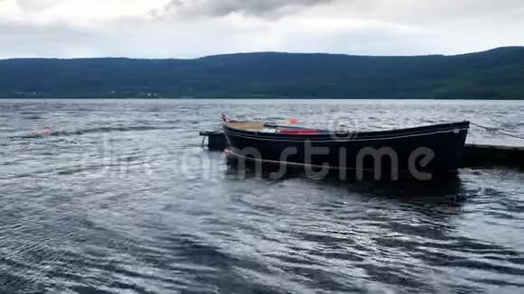 挪威阿克斯胡斯赫达尔附近多云的天空下孤独的划艇系在漂浮的湖坞里轻轻地在波浪中遨游视频的预览图