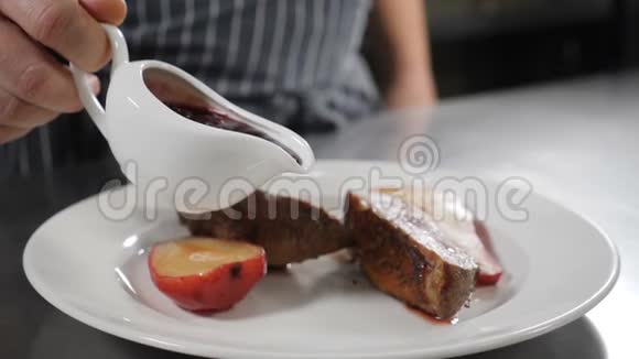 厨师将牛莓酱倒在炸鸭肉上配上美味的红梨甜点用干酒煮熟餐厅视频的预览图