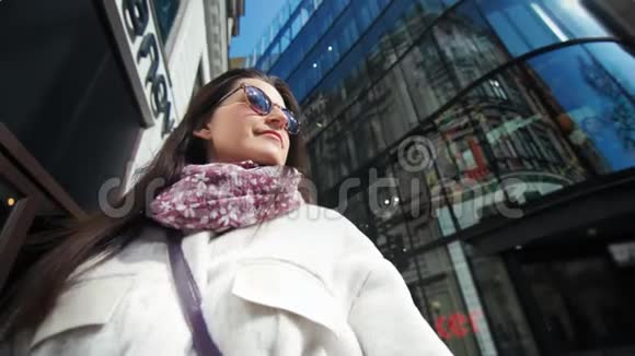 现代玻璃摩天大楼环绕的中型近景时尚女士太阳镜视频的预览图