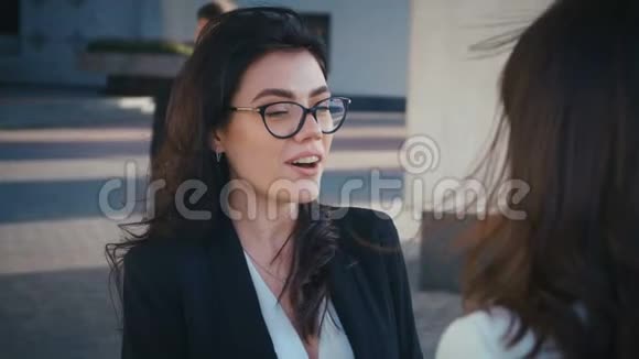 两个美丽的女人互相交谈他们一起聊天和玩在后台办公大楼视频的预览图