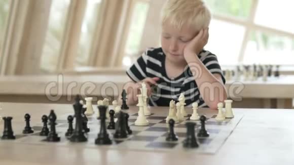 孩子下棋男孩玩白色的棋子视频的预览图