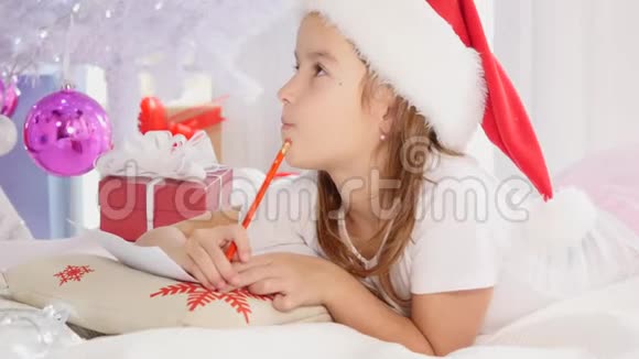 专注的孩子参与了思考她所有的愿望和愿望的过程给圣诞老人写了一封信视频的预览图