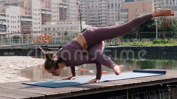 年轻女子做瑜伽运动与城市背景阿卡帕达孔迪尼亚萨纳视频的预览图