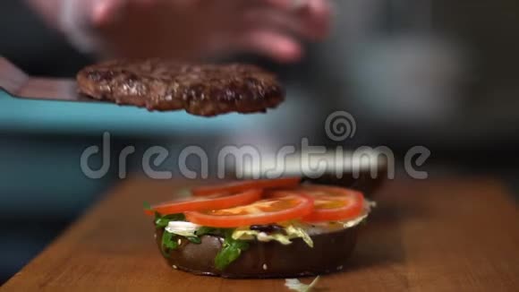快餐店的厨房厨师把切块放在汉堡上视频的预览图