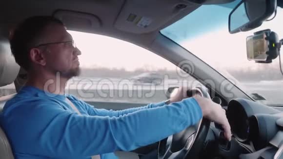 白人在高速公路上开车开车时看视频乘坐舒适的汽车进行公路旅行视频的预览图