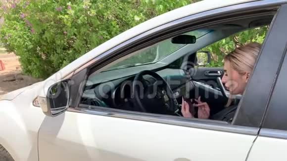 女人在车里看着电话视频的预览图