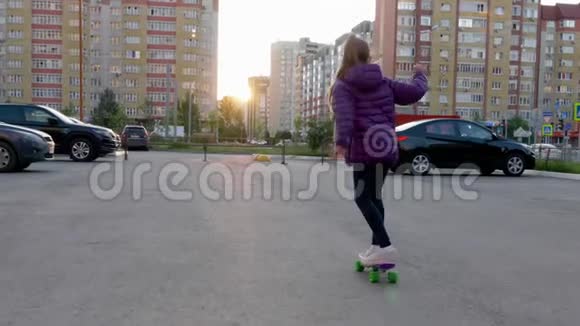 傍晚日落时慢动作女孩在城市街道上滑板在阳光明媚的街道上骑滑板的少女视频的预览图
