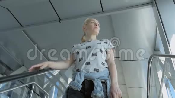 一个女人在商务中心或机场的自动扶梯下视频的预览图