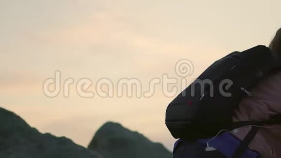 站在山顶上的女人望着日落的景色视频的预览图