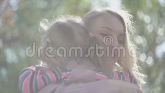 金发女郎拥抱和亲吻她的女儿在阳光下近距离家庭幸福妈妈和她的孩子视频的预览图
