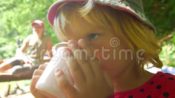 孩子喝杯子里的茶在徒步旅行路线上休息视频的预览图