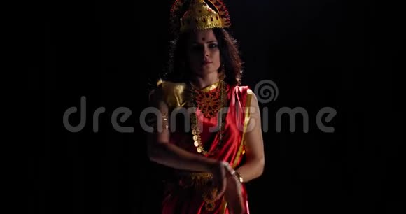 穿着传统红裙的拉克什米在黑色背景下跳舞4k视频的预览图