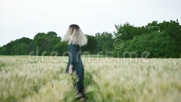 一个快乐迷人的白人金发美女的肖像湿发在雨中旋转的自然小麦室外地视频的预览图