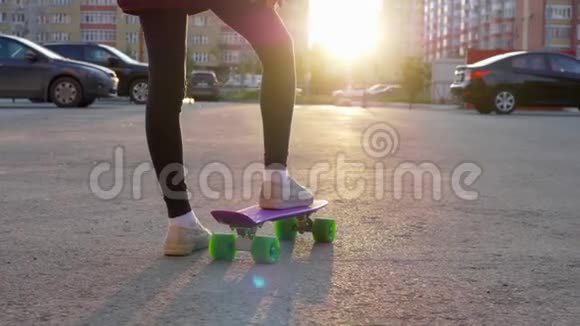 年轻女孩滑板在城市街道上阳光背景和城市建筑少年女孩骑滑板视频的预览图