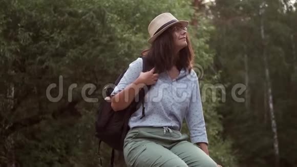 女旅行者在森林里休息一位戴着帽子的年轻女游客的肖像视频的预览图
