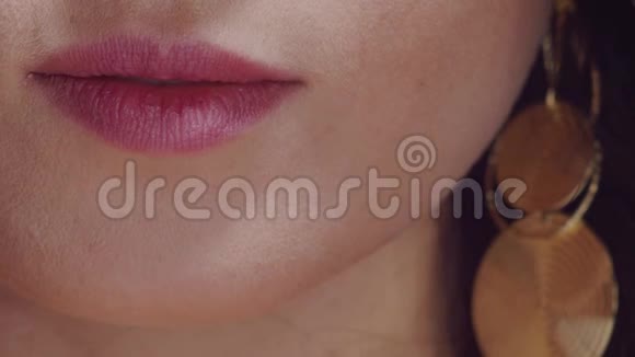 把戴耳环的年轻女人的嘴唇贴紧视频的预览图