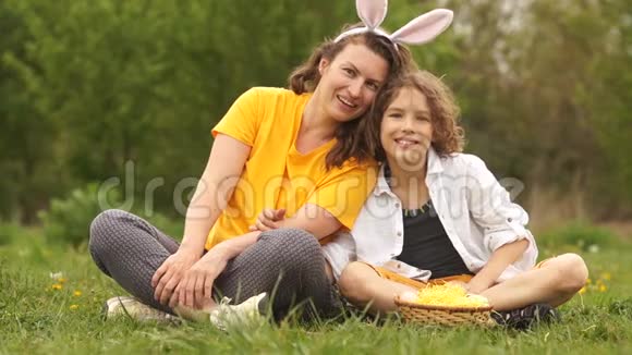 妈妈和儿子在复活节野餐兔子服装一家人幸福的家庭周末视频的预览图
