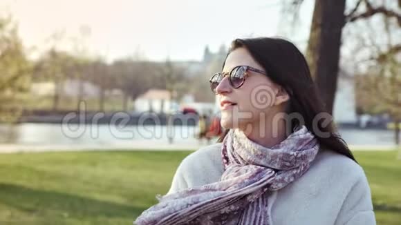 中度特写微笑时尚的女性在秋天的城市公园或日落时漫步视频的预览图