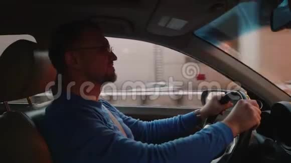 白人司机在车里开进出出舒适的地方手机持有人的智能手机视频的预览图