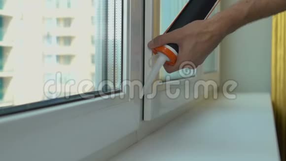 安装公寓维修服务特写后工人在新窗户上涂油视频的预览图