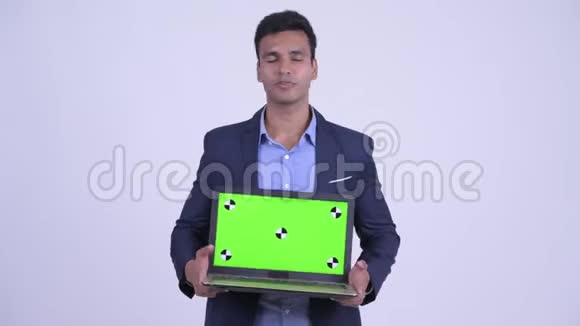 快乐的年轻印度商人一边说话一边展示笔记本电脑视频的预览图