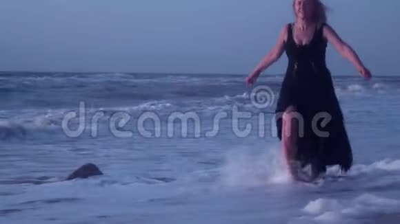 女人逃离海浪大海的泡沫在沙滩上刮风视频的预览图