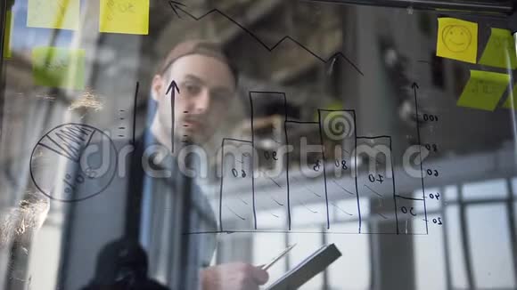 年轻迷人的时髦男人在检查玻璃板上的图表视频的预览图