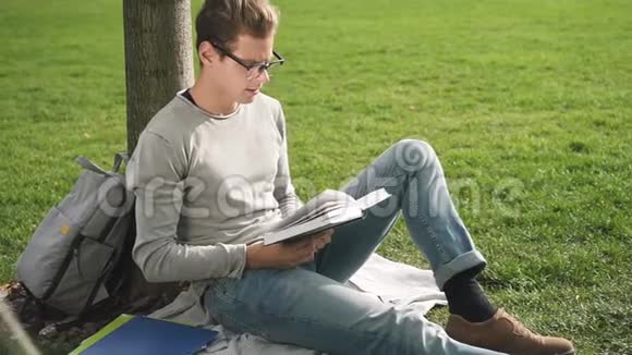 年轻人的生活方式模范企业家商人悲伤地坐在草地上阅读文件致力于新的工作视频的预览图