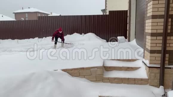 年轻人在房子附近铲雪视频的预览图