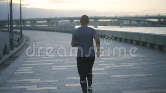 年轻健康的黑人男子训练和建立他的身体在人行道上缓慢地运动做脂肪和运动视频的预览图