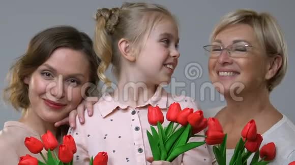 三代妇女手持郁金香家庭传统庆祝3月8日视频的预览图