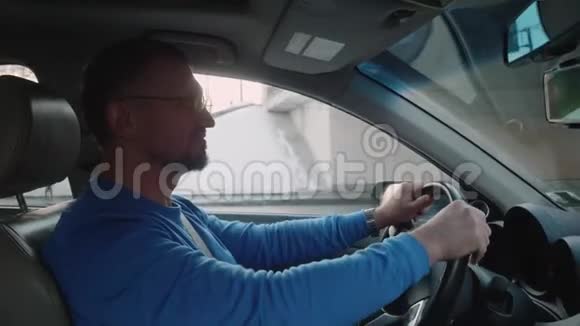白人男性司机开车进入地下通道并微笑冬天的下午视频的预览图