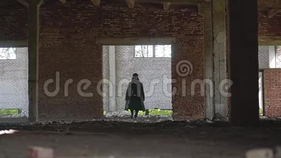 那一个很好的框架破碎的废弃建筑这个房间是一个穿着雨衣和帽子的人视频的预览图