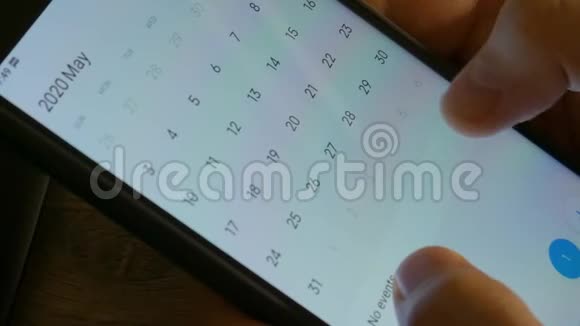 人使用日历APP上的移动设备特写特写男性手滚动屏幕上的智能手机视频的预览图