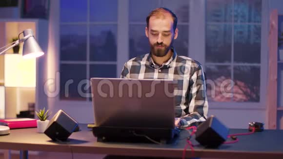 工作过度的人在家工作到很晚用笔记本电脑视频的预览图