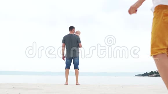 海滩上有三个孩子的年轻人他父亲和两个十几岁的孩子一个男孩和一个女孩视频的预览图