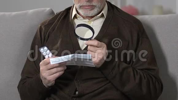 老年男性用放大镜阅读药片的剂量和注意事项治疗方法视频的预览图
