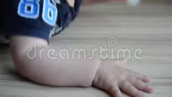可爱的七个月大的小男孩试图接触地板上的假人视频的预览图