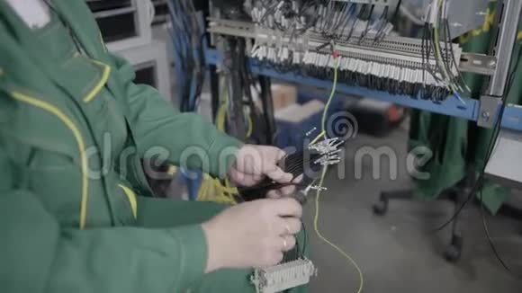 工厂电工工程师用螺丝刀安装电缆将电子箱控制柜中的螺母拧紧到视频的预览图