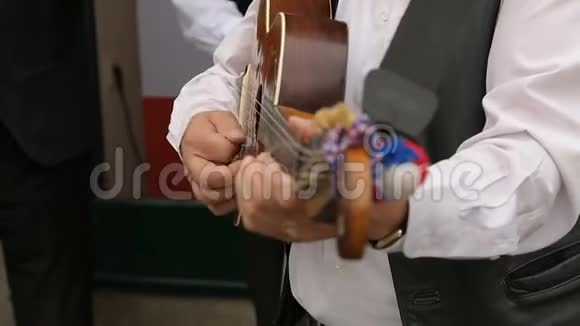 街头弹吉他的男音乐家特写音乐表演视频的预览图