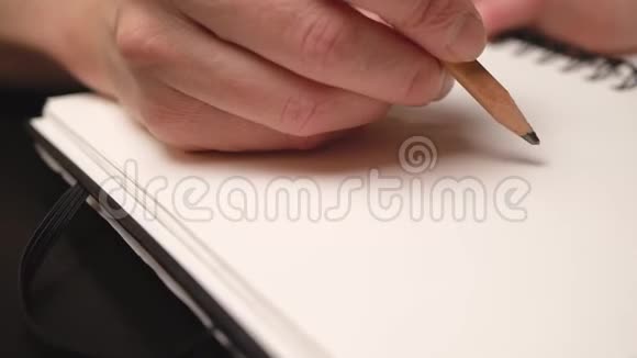 女人用铅笔在素描本上画苹果快关门滑块运动视频的预览图