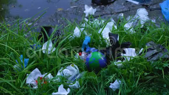 在森林湖附近的垃圾填埋场扔地球仪的人生态污染视频的预览图