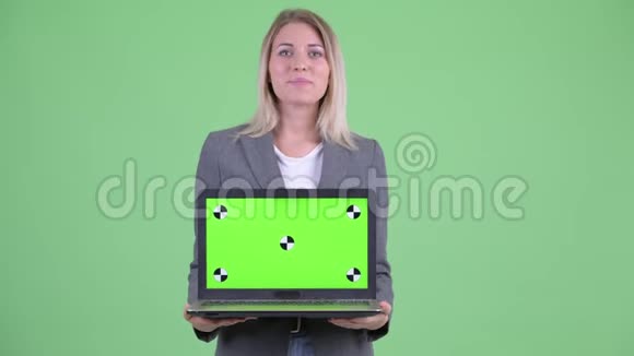 一位年轻的金发碧眼的女商人正在用手提电脑说话视频的预览图